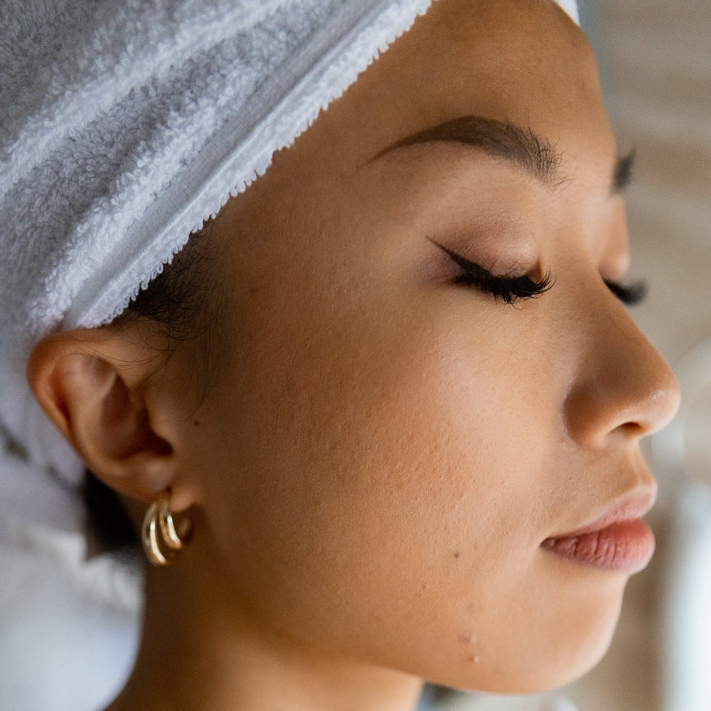 Woman in bathroom in a mindfull state of mind. The facial cream is a long-lasting moisturizing and protective facial cream for radiant, fresh-looking skin.