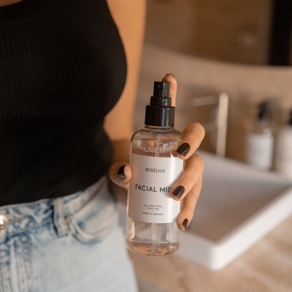 Woman holding facial mist. Bigelius skincare facial mist - a boosting, refreshing, airy and hydrating mist that helps to prevent premature aging of the skin caused by environmental pollution.